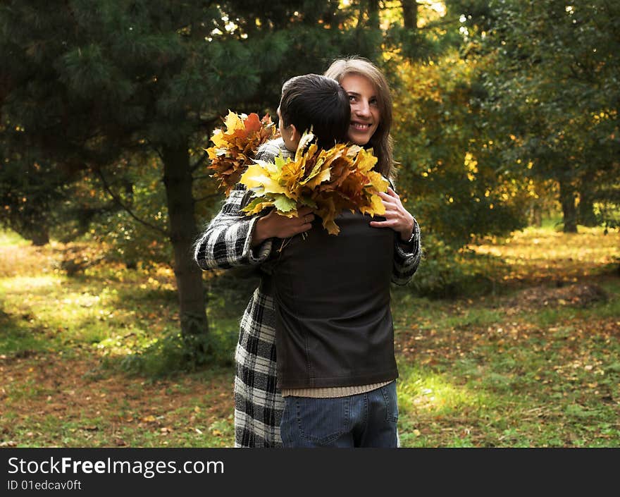 Young and beautiful husband and wife walking in an autumnal park. Young and beautiful husband and wife walking in an autumnal park