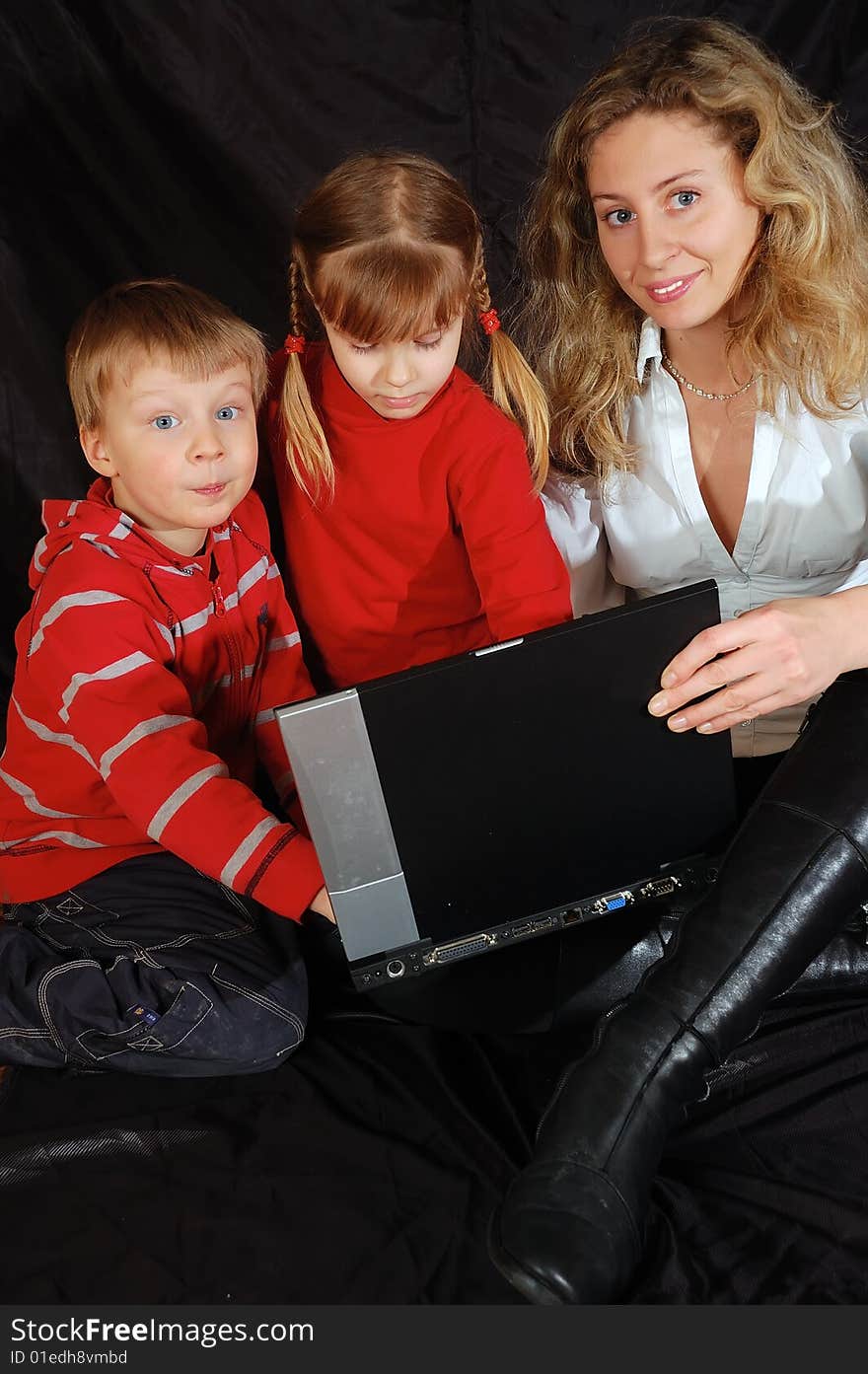 Young woman teaches two 4 year old kids with a laptop. Young woman teaches two 4 year old kids with a laptop