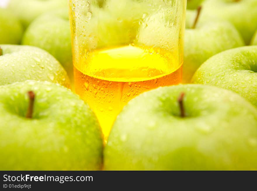 Glass with juice among ripe green apples. Glass with juice among ripe green apples