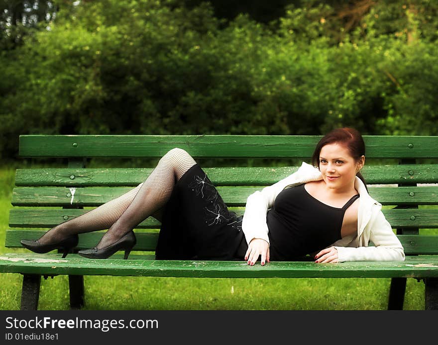 Portrait of a girl lying on the bench in park. Portrait of a girl lying on the bench in park