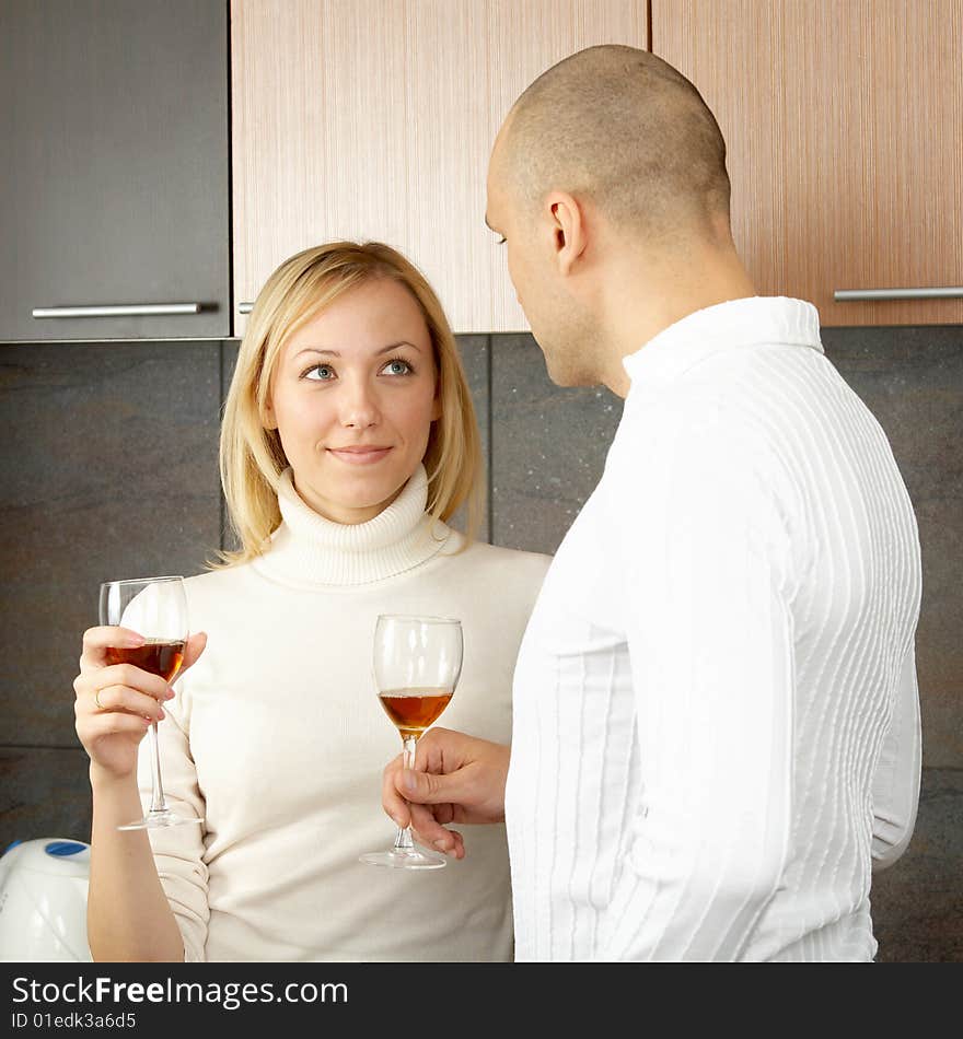 Pair on kitchen drink wine from glasses. Pair on kitchen drink wine from glasses