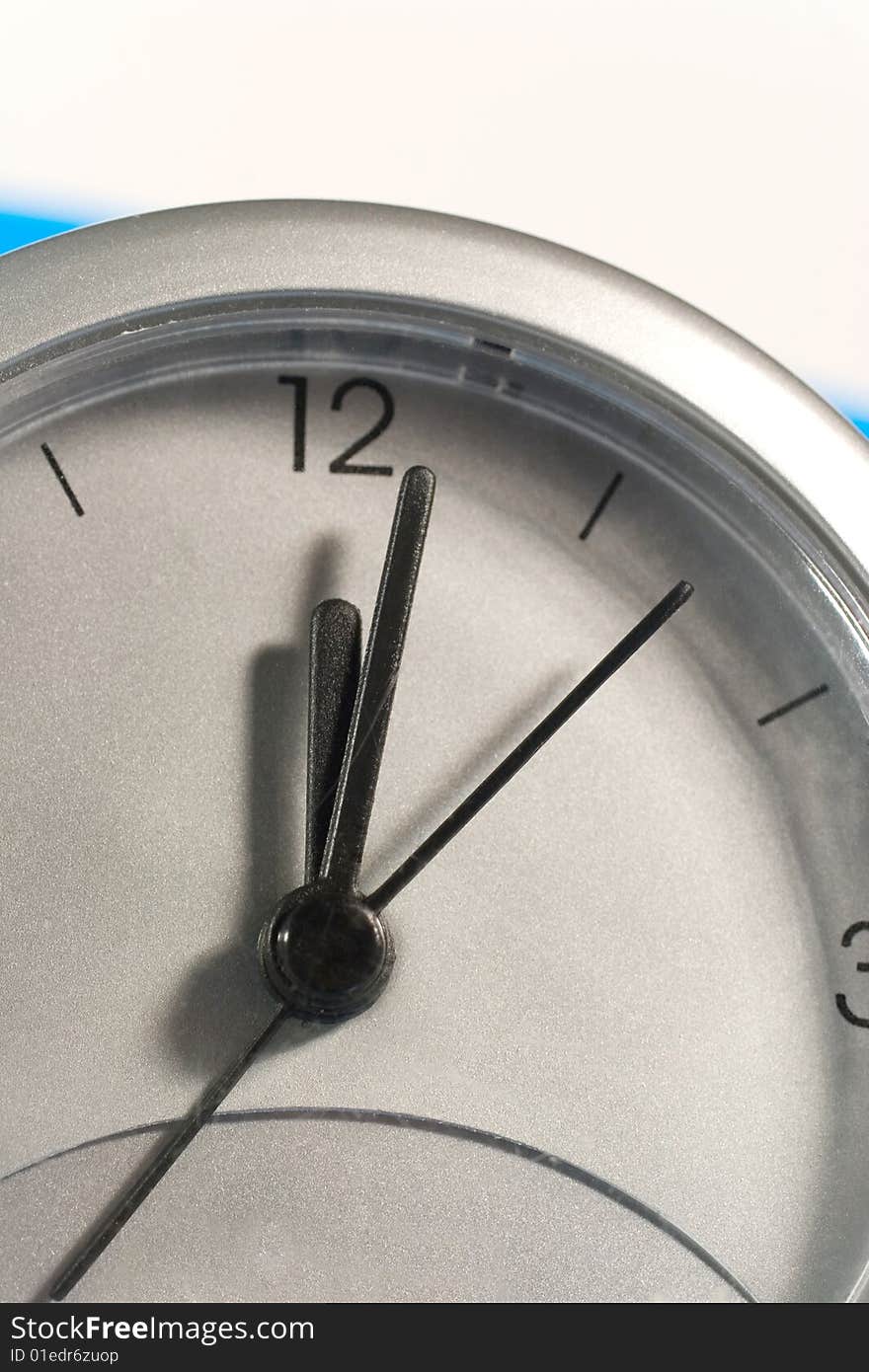 Closeup of a clock face (on a blue and white background)