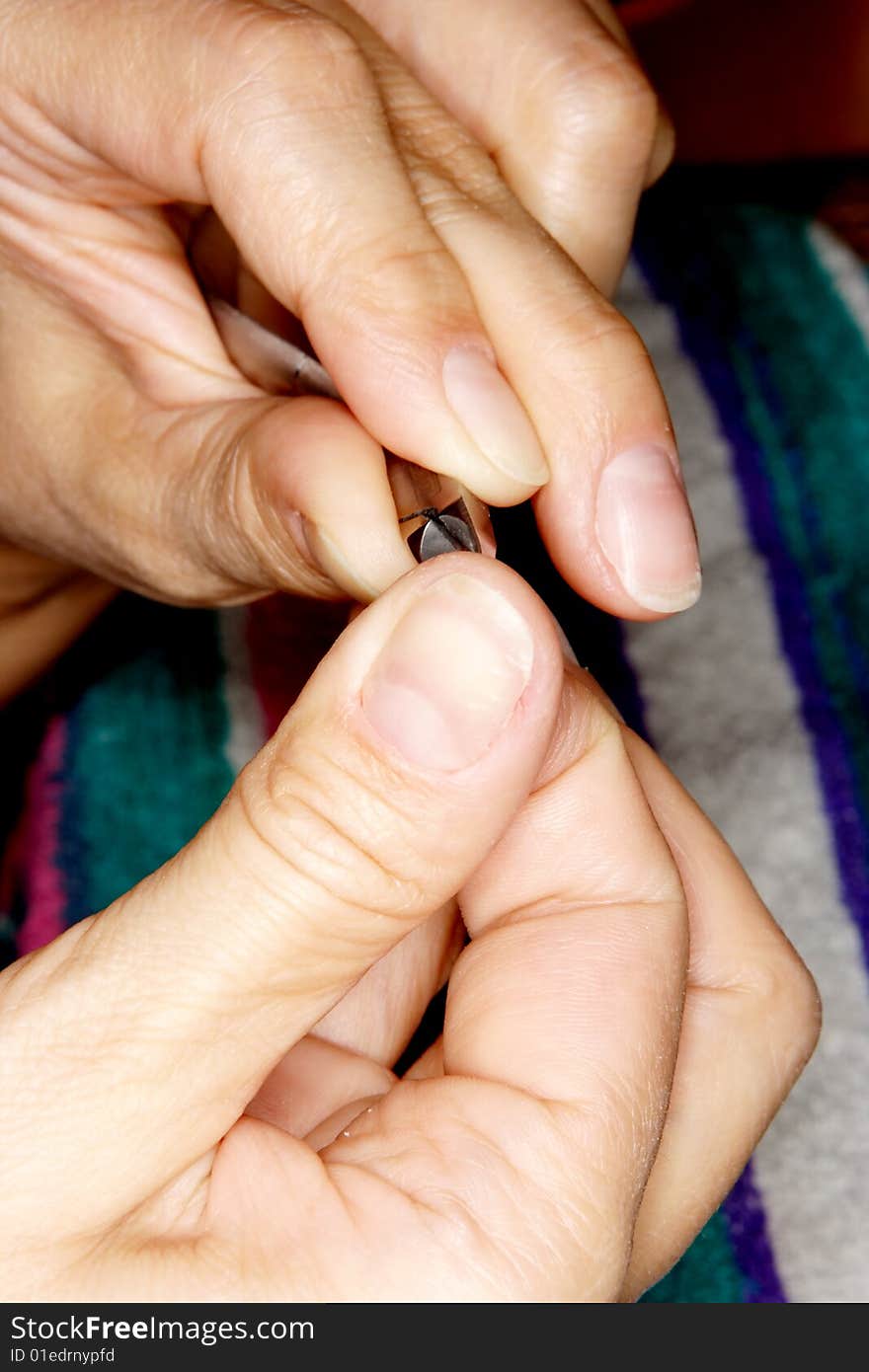 A girl making manicure using clippers