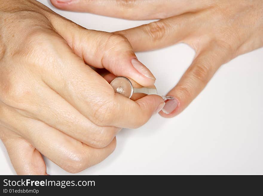 A girl making manicure using clippers