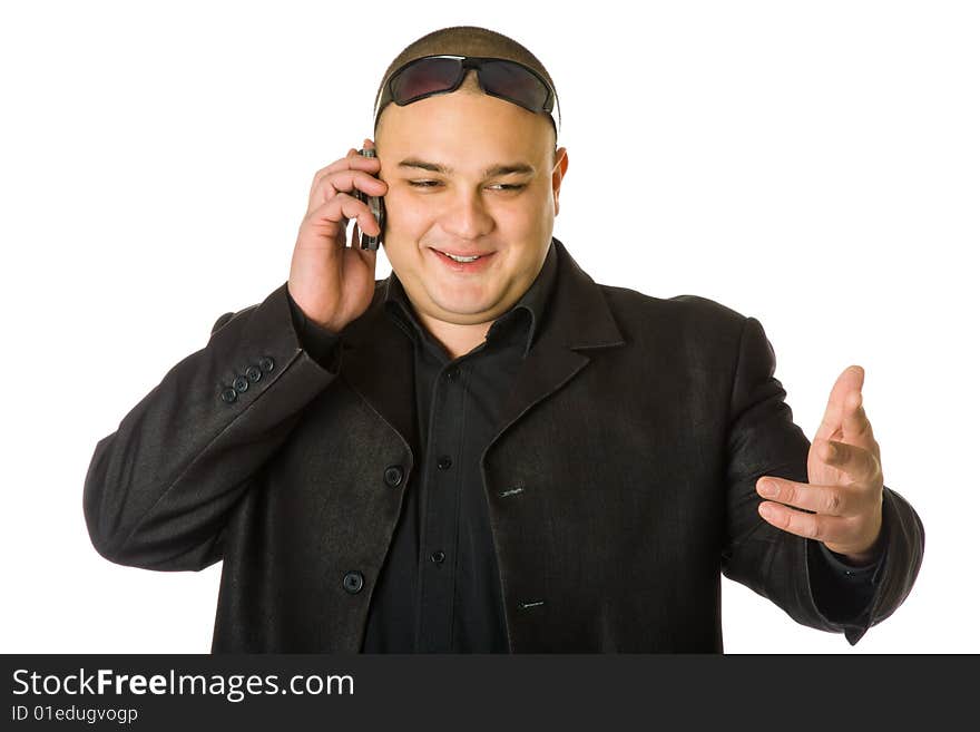 Man in black suit in sun glasses talking on the mobile phone. Isolated on white background