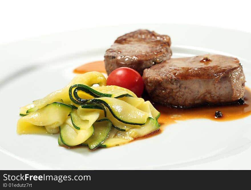 Veal Medallions with Zucchini and Cherry Tomato. Isolated on White Background