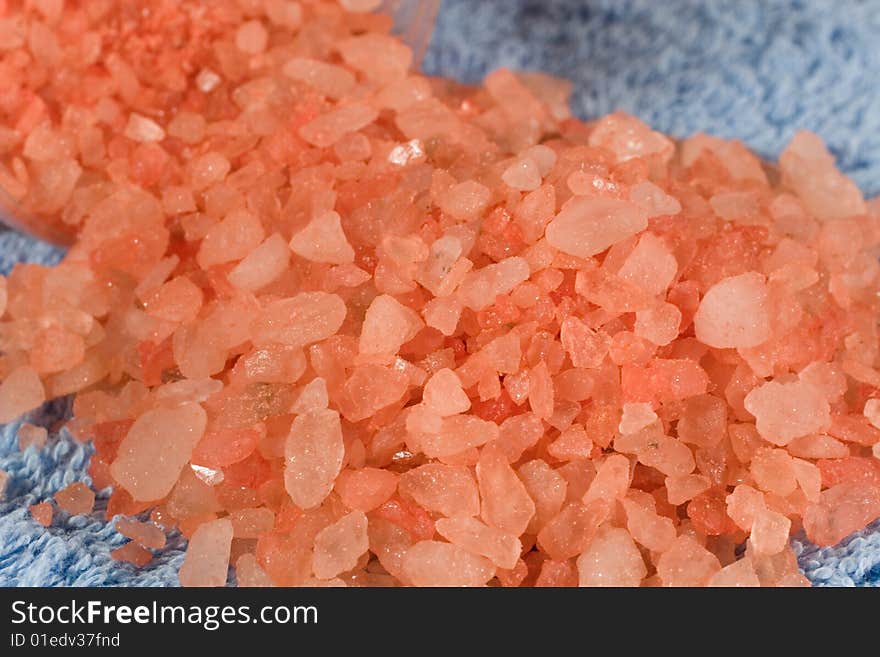 Pink bath salt on a blue towel (as a background)