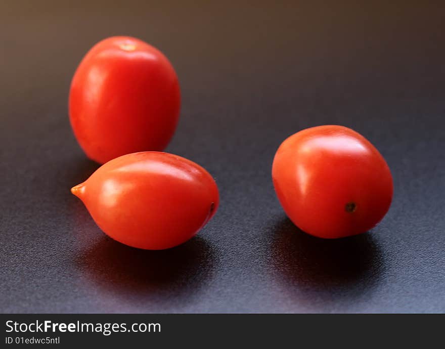 Three tomatoes isolated on black background