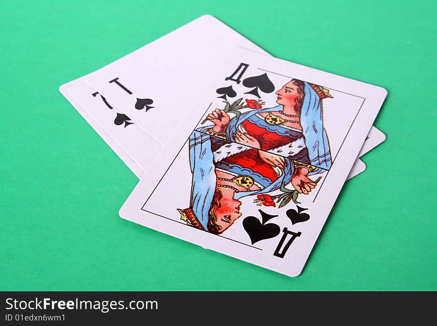 Some playing cards and lady peak from above on a green background. Some playing cards and lady peak from above on a green background