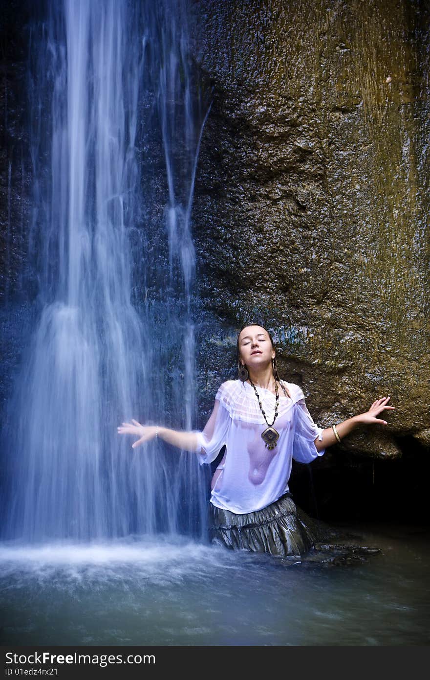 Young woman under blue waterfall. Young woman under blue waterfall