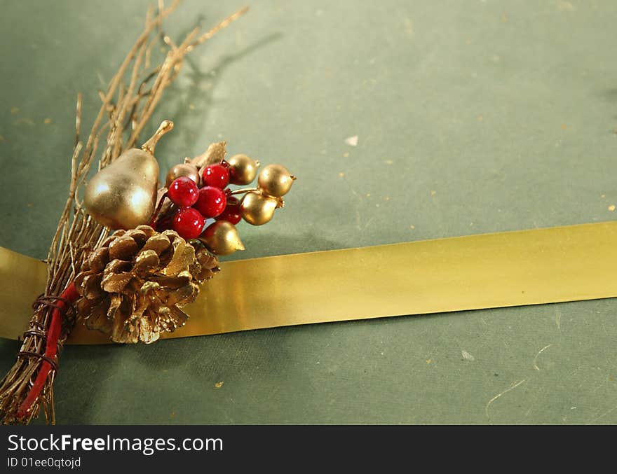 Christmas decoration and a golden ribbon on a green wrapping with copy space. Christmas decoration and a golden ribbon on a green wrapping with copy space