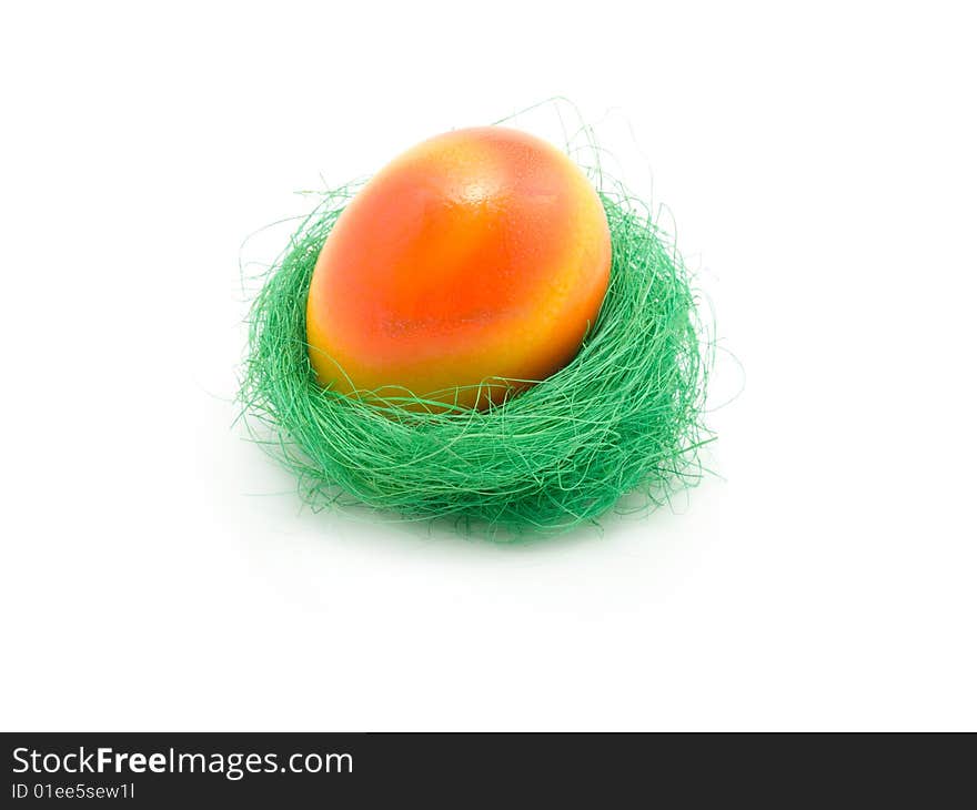 Colorful Easter egg in nest isolated in white background.