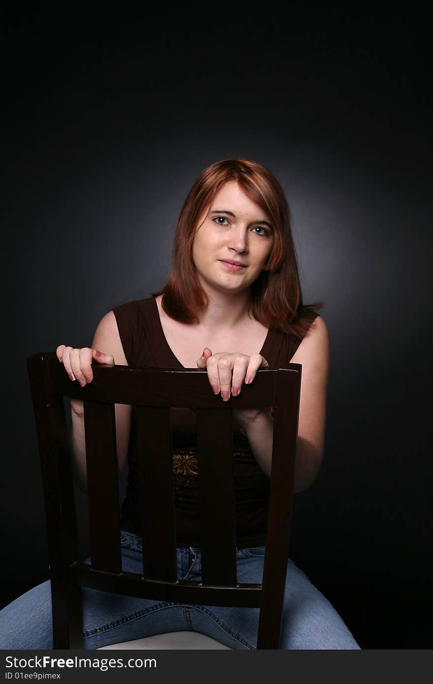 Pretty teenage girl with red hair in a chair. Pretty teenage girl with red hair in a chair