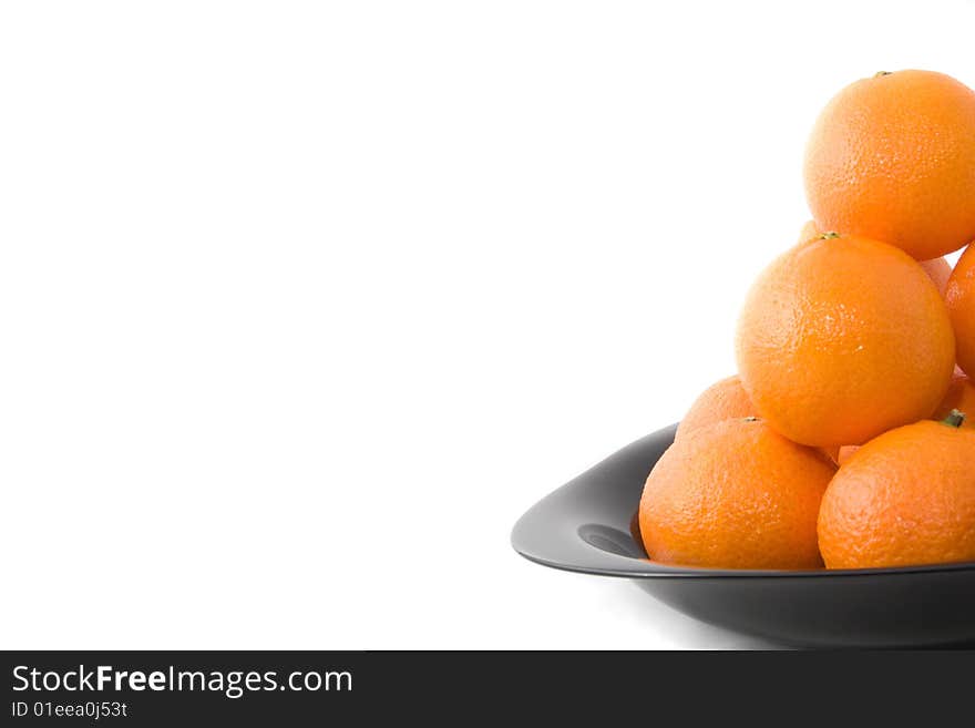 Tasty orange tangerines on black plate isolated on white. Tasty orange tangerines on black plate isolated on white