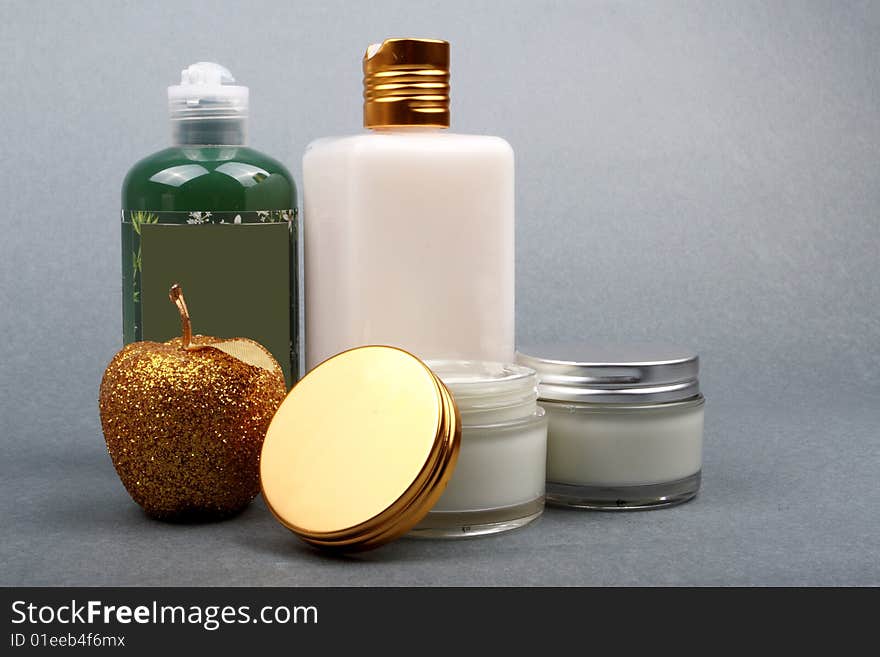 Different beauty products with apple flavor on grey background. Different beauty products with apple flavor on grey background.