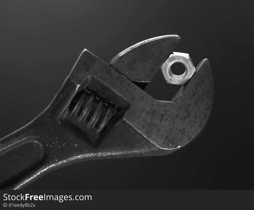 Flat wrench with nut on dark background