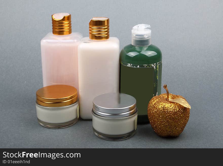 Different beauty products with apple flavor on grey background. Different beauty products with apple flavor on grey background.