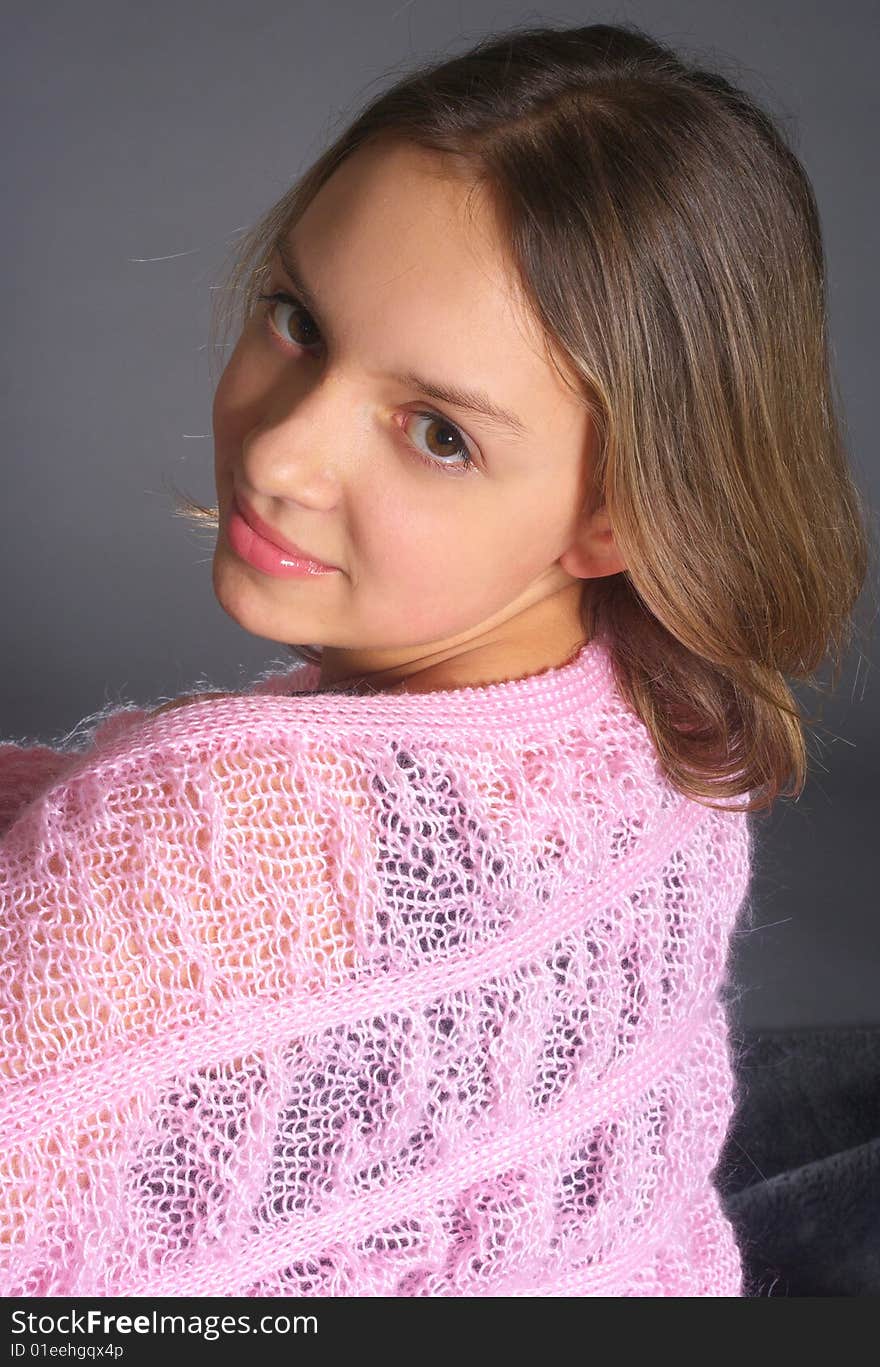 Portrait of teenage girl with pink shawl on grey background