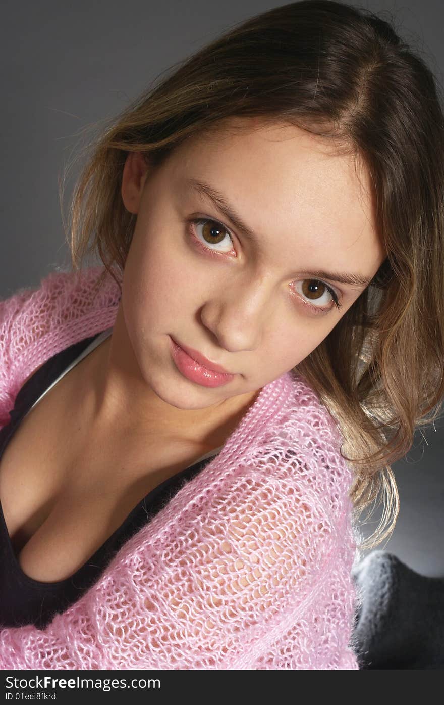 Portrait of teenage girl with pink shawl on gray background