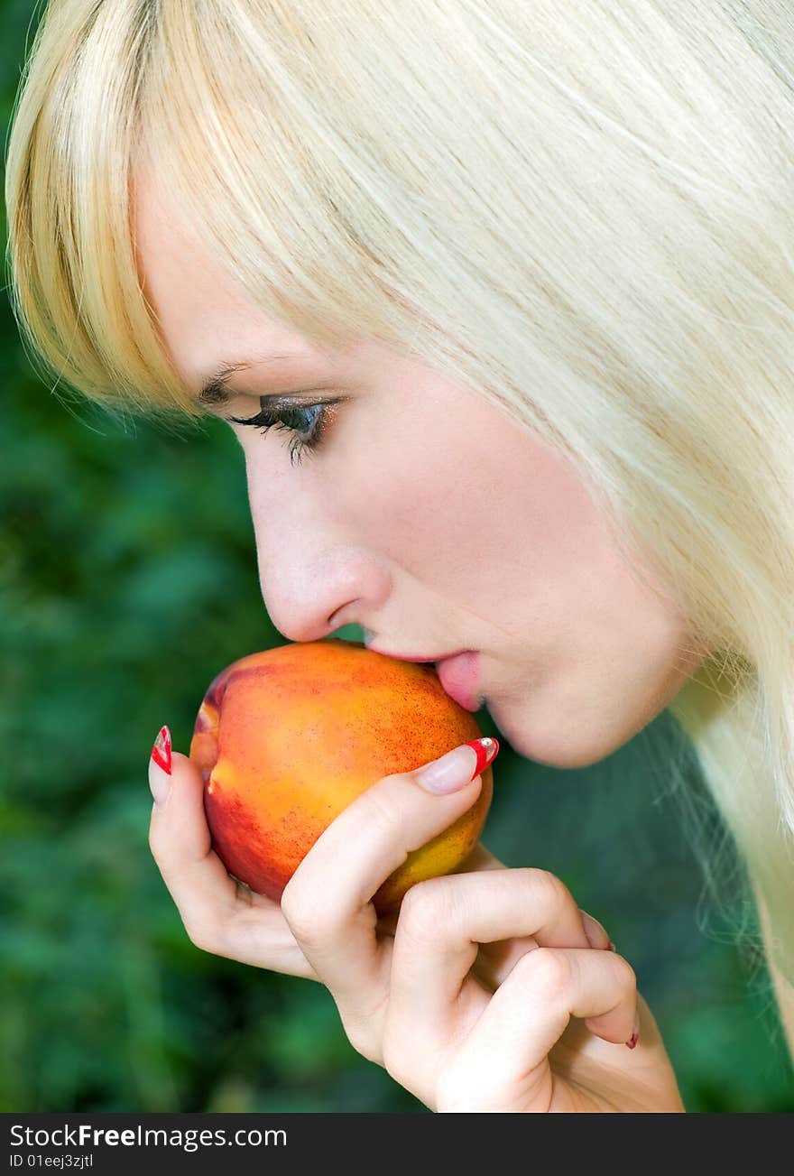 Attractive girl with the peach in her hand