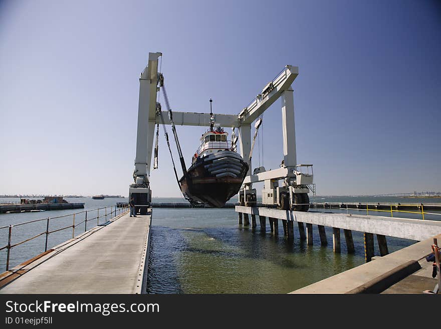 Tug Boat being lifted out of the water going into dry dock