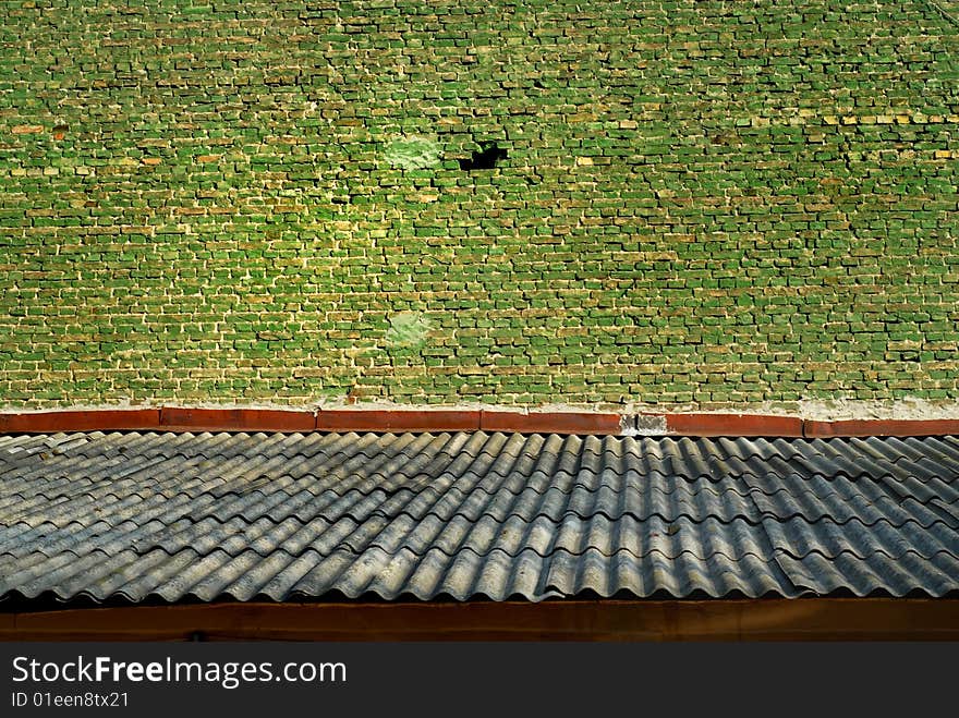 Old green bricks wall and shiver roof