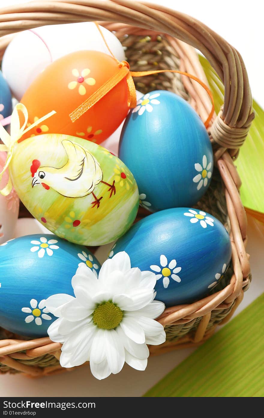 Easter basket with easter eggs and flower.