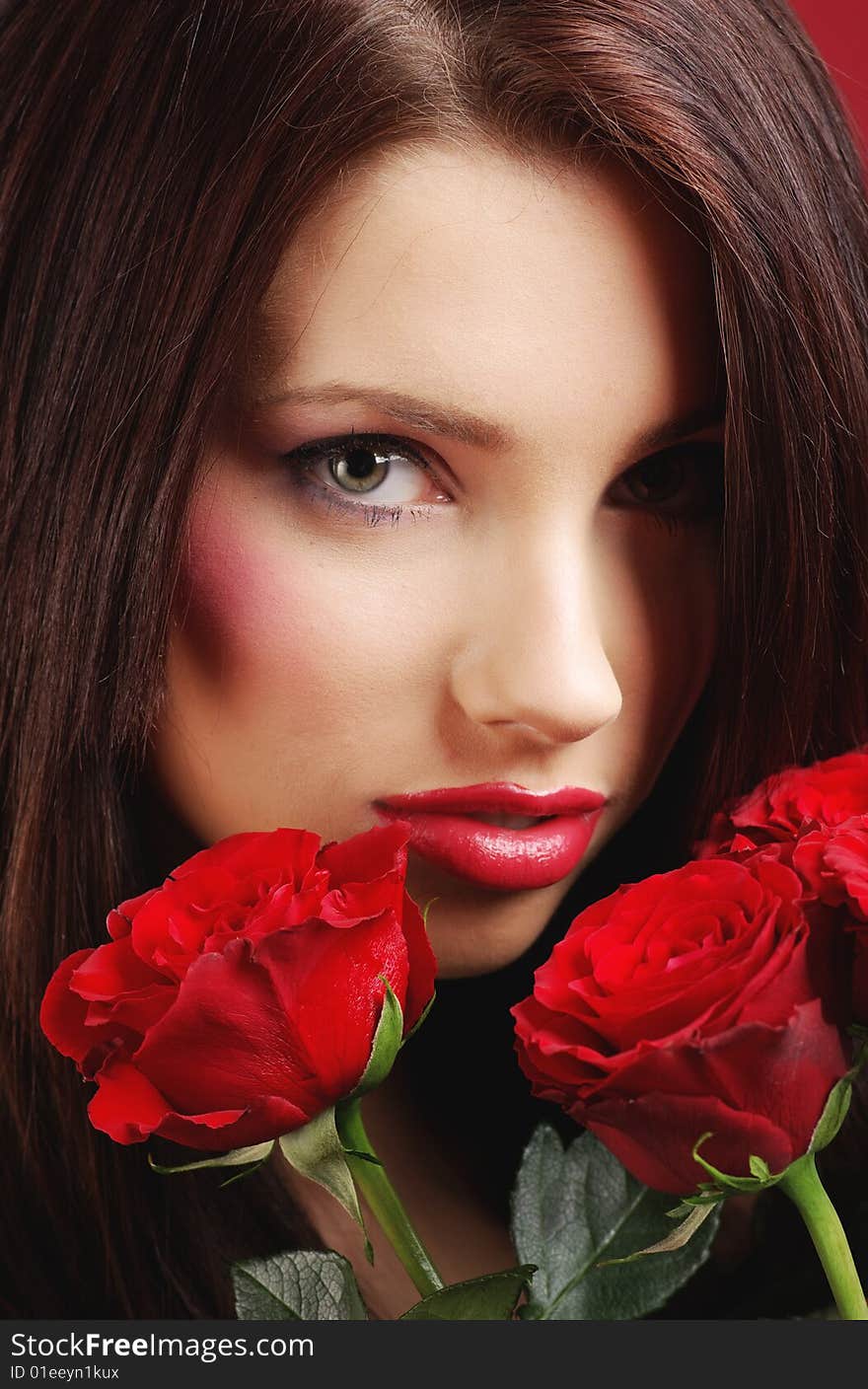 Close-up studio portrait of a beautiful sexy woman with red rose, shoot  on red background