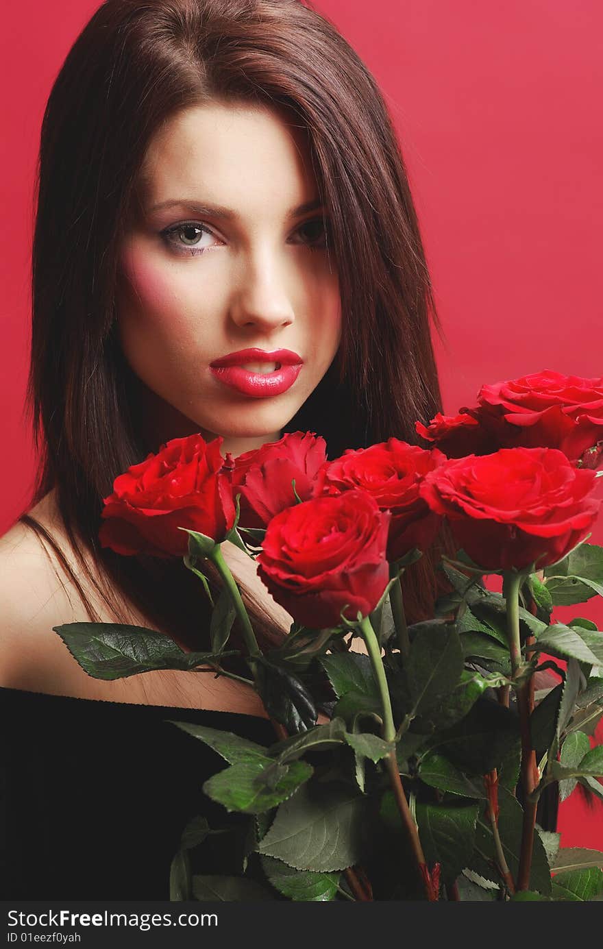 Close-up studio portrait of a beautiful sexy woman with red rose, shoot  on red background