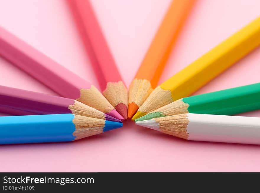 Semicircle of pencils on pink background