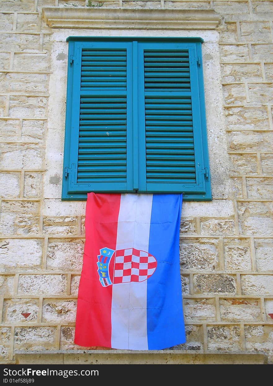 A wall with blue window & Croatian flag