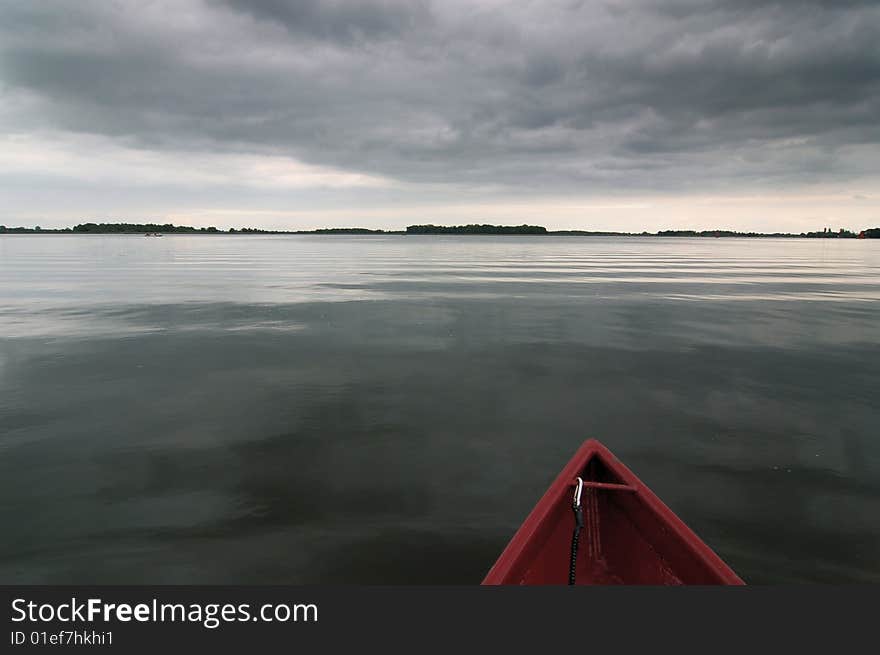 A sail boat on a quiet lake.