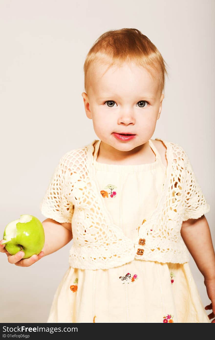 Studio portrait of a little girl holding a green apple. Studio portrait of a little girl holding a green apple