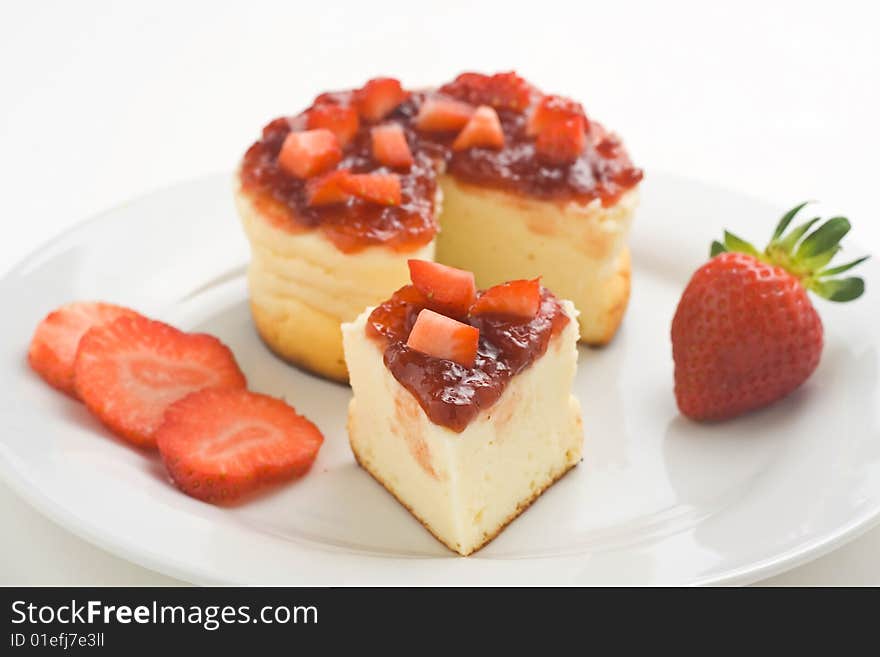 Cheesecake with fresh strawberries and blackberry jam isolated over white