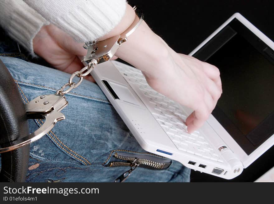 Hand in handcuffs on laptop