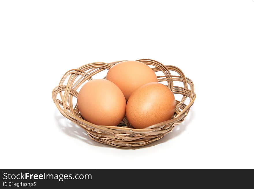 Three eggs in the wooden basket.