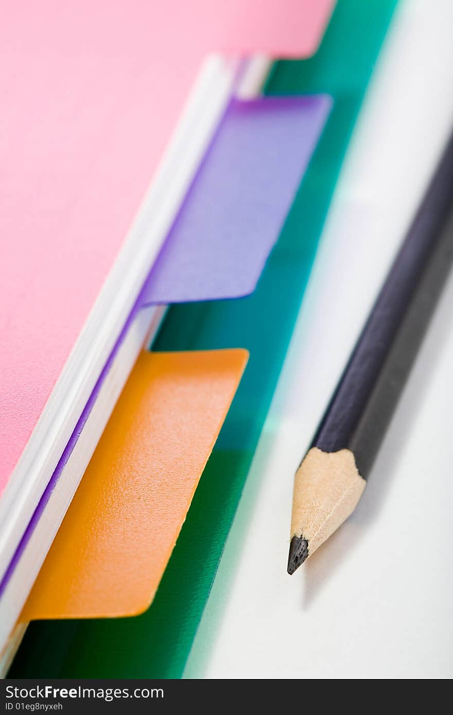 Stock photo: office theme: an image of part of pink notebook and a pencil. Stock photo: office theme: an image of part of pink notebook and a pencil