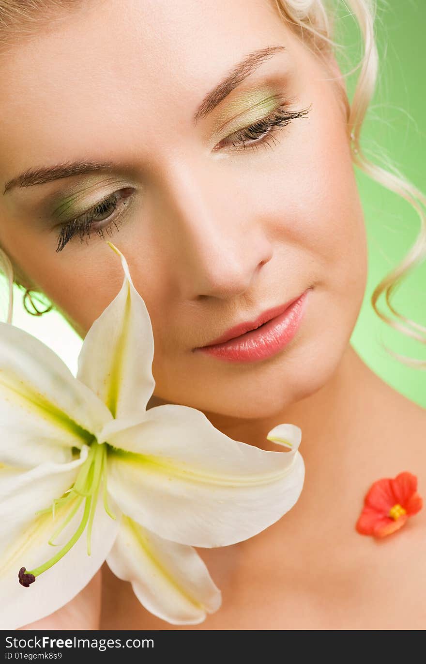 Beautiful young woman with lily flower. Close-up portrait