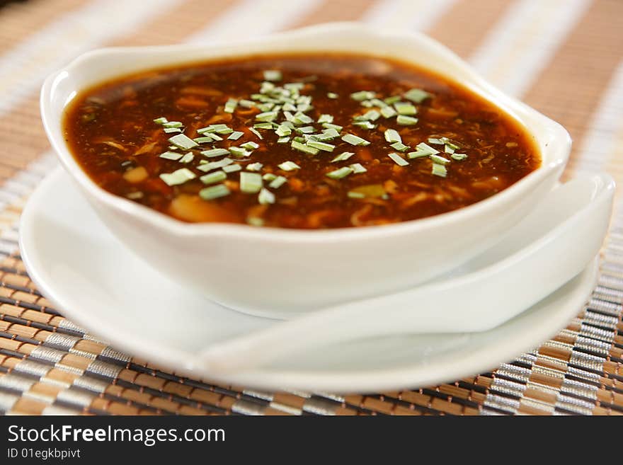 Dark spring vegetable soup with leek on plate