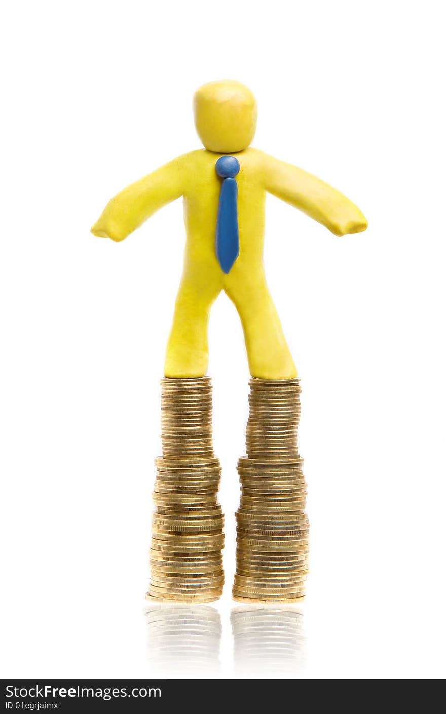 Plasticine businessman stands on two heaps of gold coins. Plasticine businessman stands on two heaps of gold coins