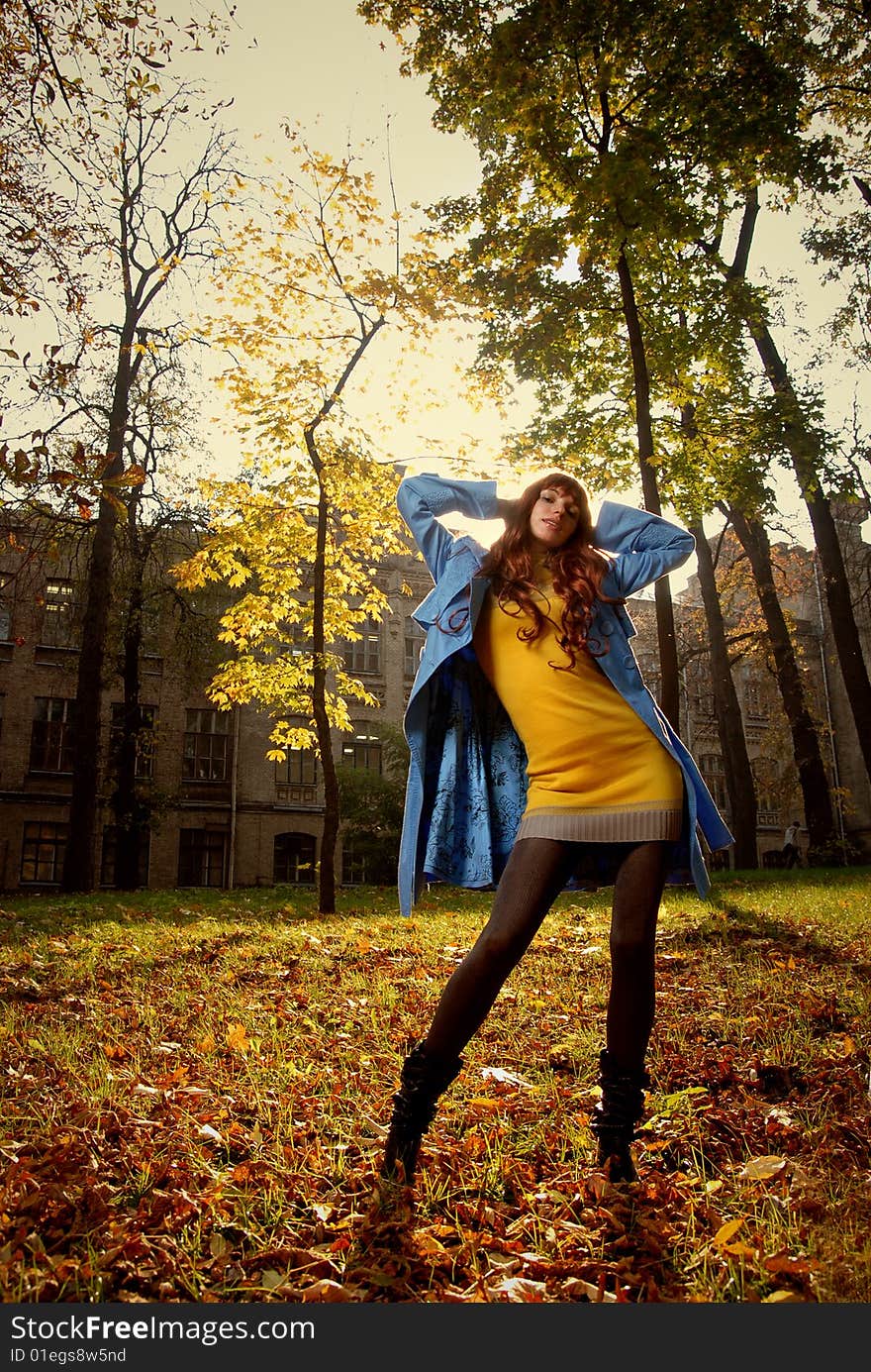 Woman in blue jaket posing in autumn park