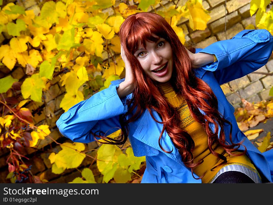 Woman in blue jaket posing in autumn park