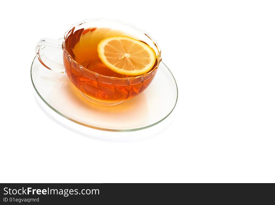 Glass cup with tea and a lemon on a white background