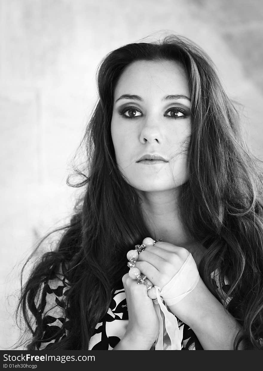 Black-and-white portrait of beautiful girl with hands like praying