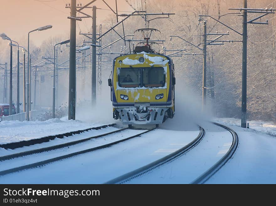 Incoming suburban train in the misty winter sunset