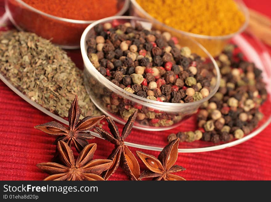 Spices in small glass bowl on red background