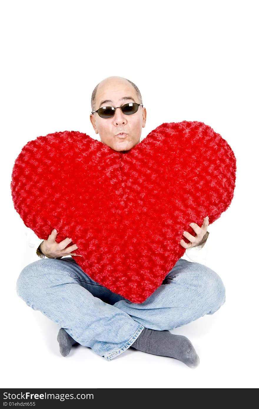 A handsome Latin man sitting holding a big red heart. A handsome Latin man sitting holding a big red heart.