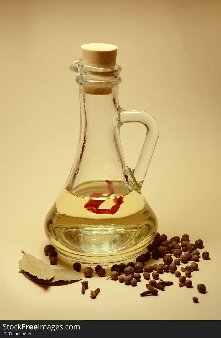 Still life on a yellow background  bottle with oil and spices. Still life on a yellow background  bottle with oil and spices