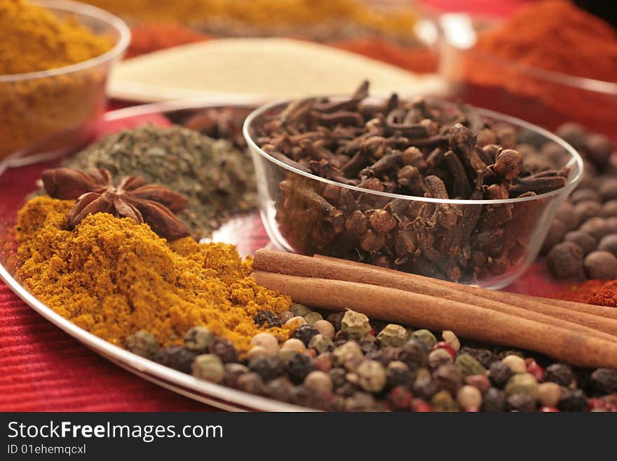 Spices on glass plates and small glass bowl