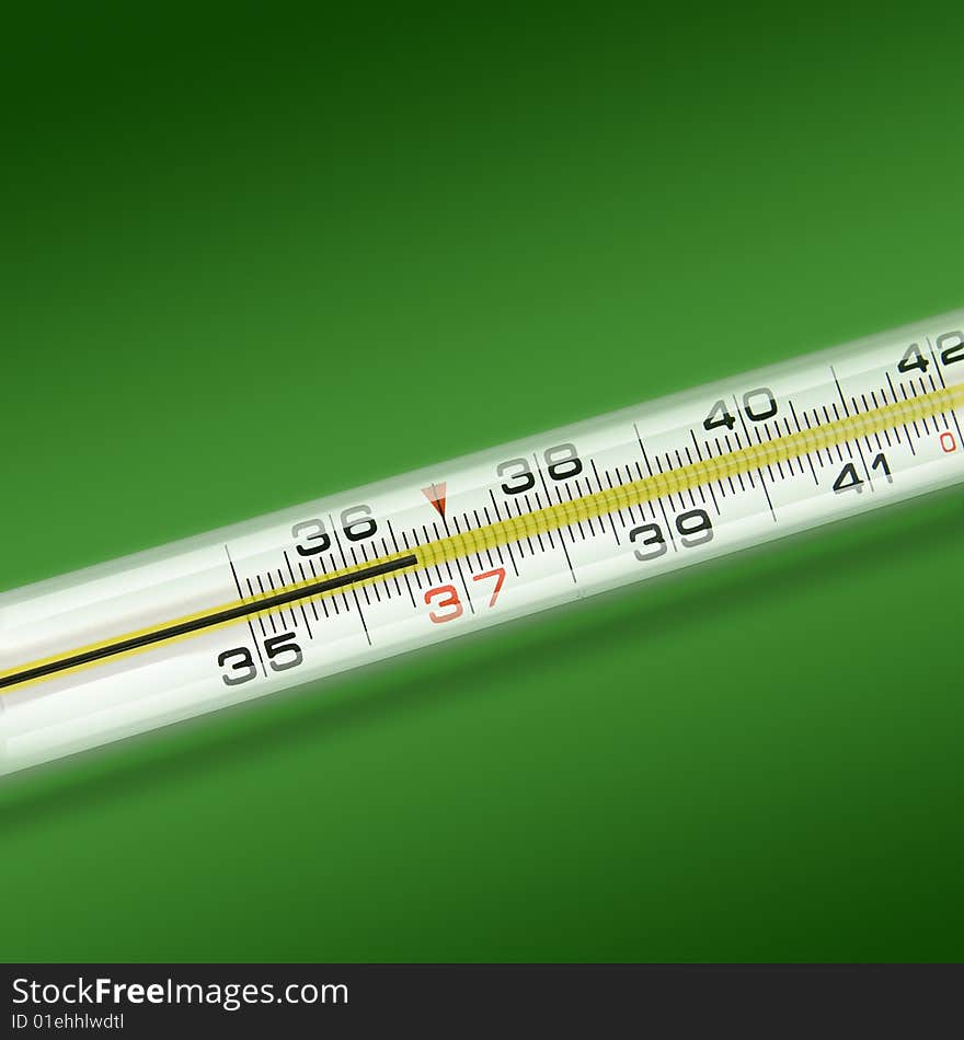 Close-up thermometer on green background